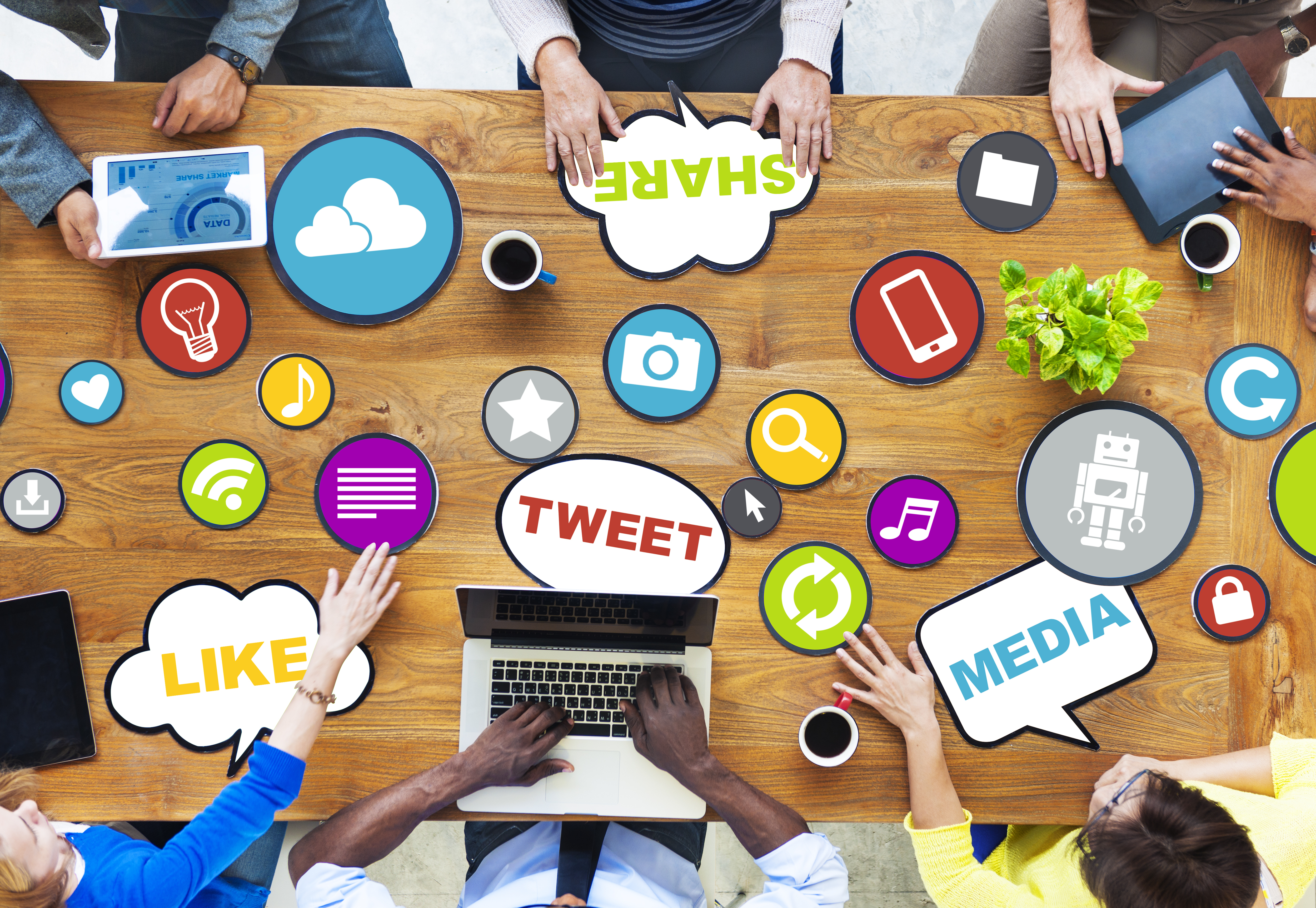 Table with social media captions on it and people gathered round